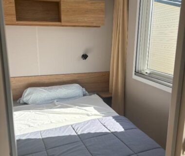 Chambre de mobilhome avec lit et fenêtre du Mobilhome 8 personnes au bord de l’Océan