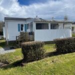 Extérieur du camping avec terrasse couverte et haies en Côtes d'Armor Mobilhome