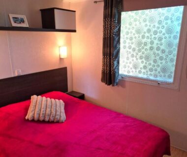 Chambre avec lit double et coussin dans le Mobilhome Argèles Plage à 500m Camping DEL MAR