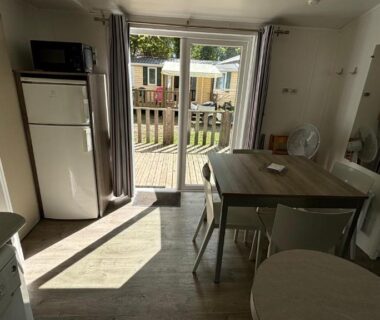 Séjour avec baie vitrée et terrasse visible du Mobilhome Avengers Camping du Ried