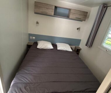 Chambre avec lit double et fenêtre dans le Mobilhome Avengers Camping du Ried
