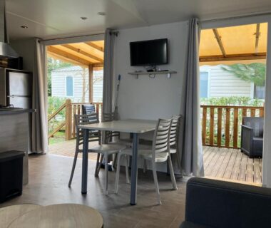 Intérieur avec table et terrasse du Mobilhome Calina camping 4 etoiles les viviers Cap-Ferret