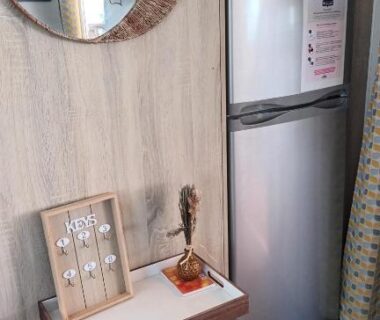 Coin cuisine avec réfrigérateur et miroir dans le mobilhome Camping La Carabasse Vias Plage