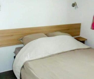 Intérieur chambre avec lit et étagère dans le Mobilhome Canet-en-Roussillon