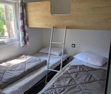 Chambre avec deux lits simples et lit superposé dans le Mobilhome Claouey