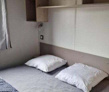 Chambre avec lit et étagères dans le Mobilhome Clim Télé La Falaise 4 étoiles