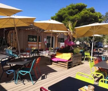 Terrasse ombragée avec parasols et chaises au Mobilhome Clim Télé La Falaise 4 étoiles