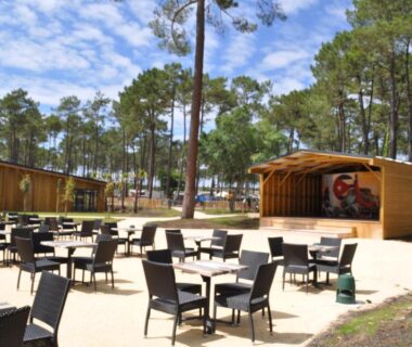 Terrasse extérieure avec tables et chaises dans la pinède au Mobilhome Côte Landaise Les Dunes de Contis 4