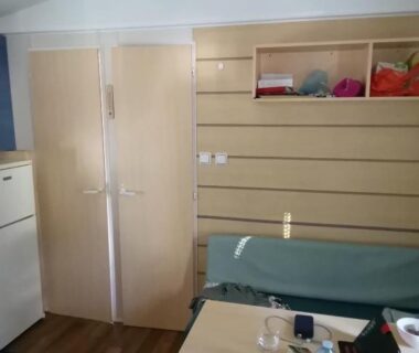 Intérieur avec coin repas banquette et rangements dans le mobilhome L'Oasis Camping le Clos Cottet