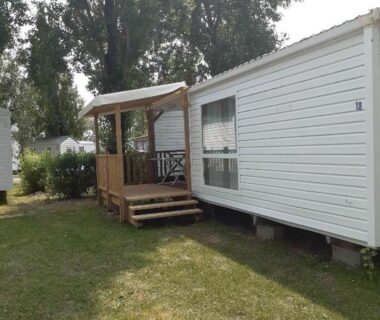 Emplacement herbeux avec terrasse en bois du Mobilhome L'Oasis Camping le Clos Cottet