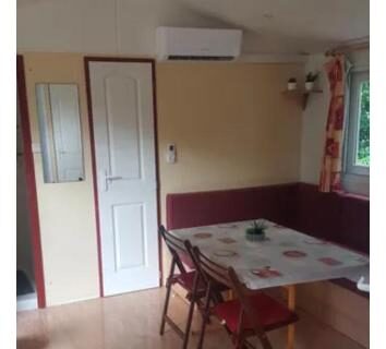 Séjour avec table et chaises dans le mobilhome M 4 à 6 personnes