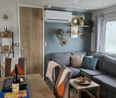Salon avec canapé table et climatisation dans le Mobilhome Normandie