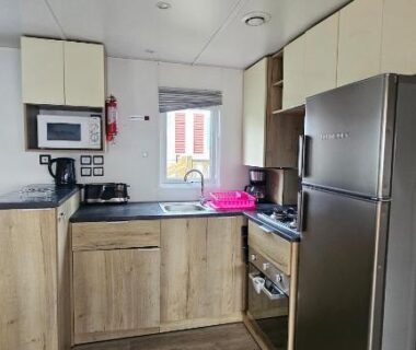 Cuisine équipée avec réfrigérateur et coin cuisson dans le Mobilhome Normandie