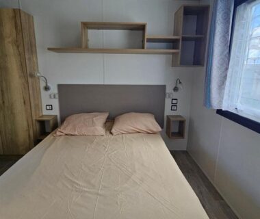 Chambre avec lit double et rangement près de la fenêtre dans le Mobilhome Normandie