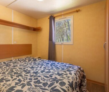 Chambre avec lit double et fenêtre du Mobilhome Oasis village Puget