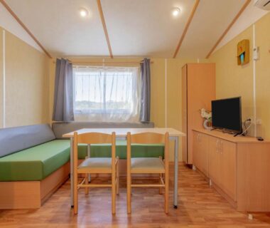 Intérieur du mobilhome avec coin repas canapé télévision du Mobilhome Oasis village Puget