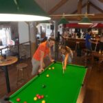 Bar intérieur avec table de billard et joueurs au Mobilhome Sables du midi