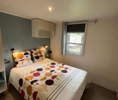 Chambre avec lit double et fenêtre dans le Mobilhome Sauvage