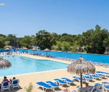 Piscine du camping avec transats et parasols en paille du Mobilhome Sauvage