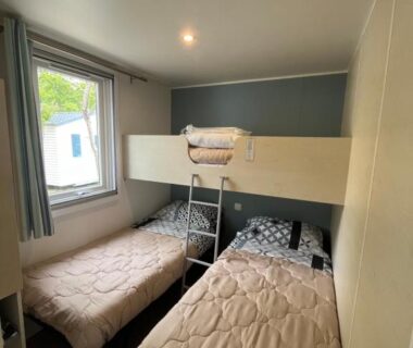 Chambre avec deux lits simples et lit superposé dans le Mobilhome Sauvage