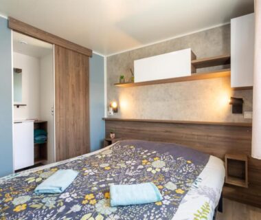 Chambre avec lit double et serviettes dans le Mobilhome Soleia 2023 Mar Estan 4x