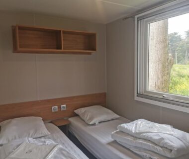 Chambre avec deux lits et fenêtre dans le Mobilhome Vue océan La Costa Breizha