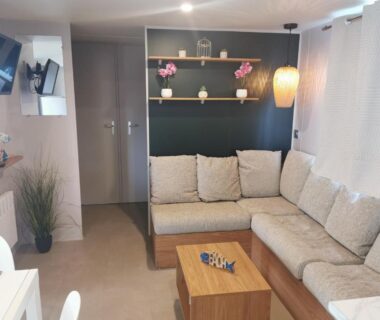 Intérieur du mobilhome avec canapé d'angle et table basse dans le Mobilhome Vue océan La Costa Breizha