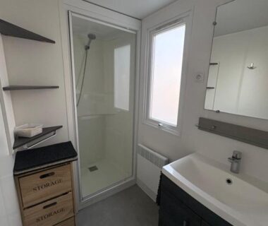 Salle de bain avec douche et lavabo dans le mobilhome a la deco zen camping sur soulac