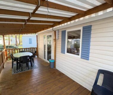 Terrasse couverte avec table et chaises du Mobilhome a la deco zen camping sur soulac