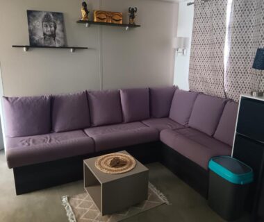 Salon avec canapé d'angle violet dans le Mobilhome a la deco zen camping sur soulac