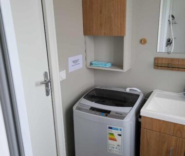 Salle d'eau avec lave-linge dans le Mobilhome au bord de l'eau