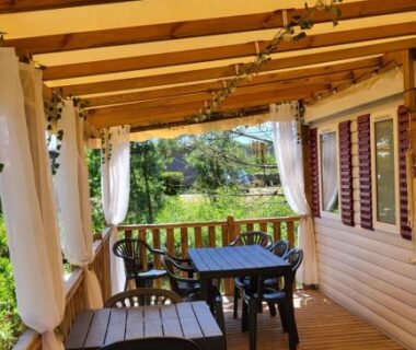 Terrasse couverte avec table et chaises du Mobilhome au bord de l'eau