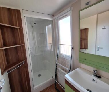 Salle de bains avec douche et lavabo dans le mobilhome au bord du lac avec piscine