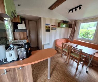 Intérieur avec kitchenette et coin repas dans le Mobilhome au bord du lac avec piscine