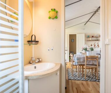 Salle de bains et coin repas visibles depuis l'entrée du Mobilhome au calme – piscine