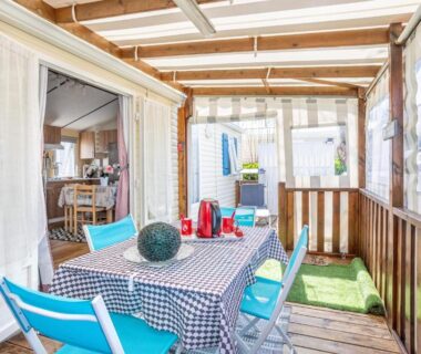 Terrasse couverte avec table et chaises du Mobilhome au calme piscine