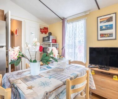 Séjour avec table télévision et kitchenette dans le Mobilhome au calme - piscine