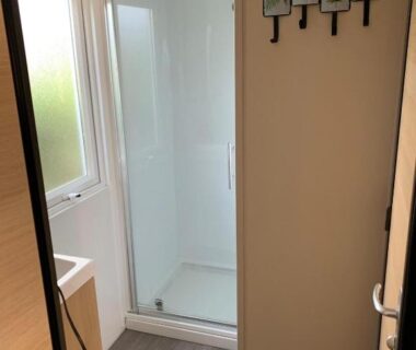 Salle d'eau avec cabine de douche et lavabo du Mobilhome avec piscine