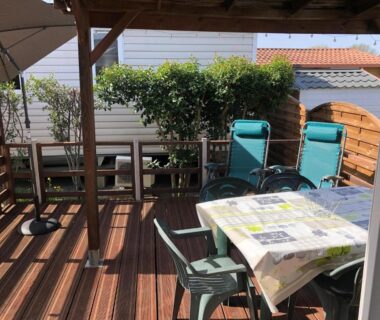 Terrasse ombragée avec table chaises et transats dans le Mobilhome avec piscine