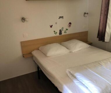 Chambre avec lits jumeaux étagères et stickers papillons dans le mobilhome avec piscine