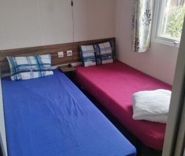 Chambre avec deux lits et fenêtre du Mobilhome beaux volumes ES40