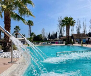 Piscine extérieure avec jets et palmiers au Mobilhome beaux volumes ES40