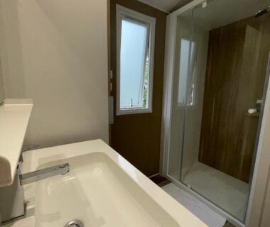 Salle de bain avec douche et lavabo dans le Mobilhome bord du lac