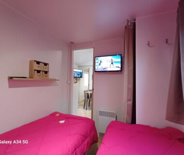 Intérieur chambre avec deux lits et télévision dans le Mobilhome camping Ernest Renan Louannec