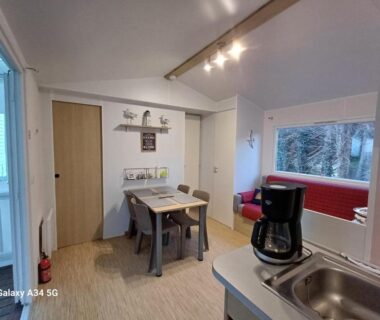 Intérieur coin cuisine et coin repas dans le Mobilhome camping Ernest Renan Louannec