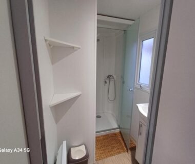 Salle d'eau avec douche lavabo et étagères du Mobilhome camping Ernest Renan Louannec