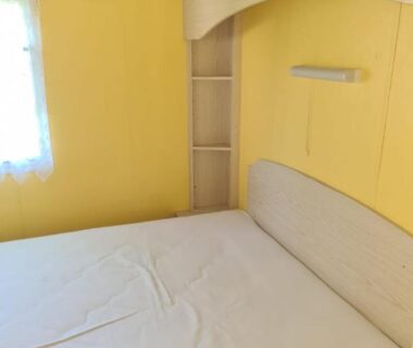 Chambre avec lit double et fenêtre dans le mobilhome camping Lalande Mimizan