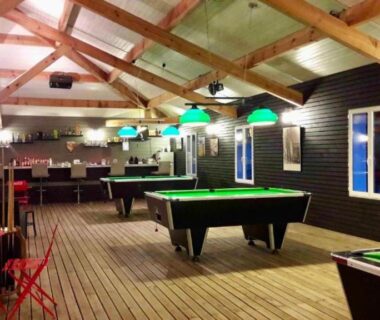Intérieur de salle de jeux avec billards et bar au Mobilhome camping Lalande Mimizan
