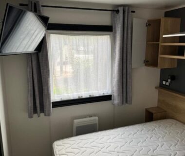 Chambre avec lit et télévision dans le mobilhome camping le BOSC
