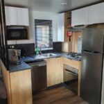 Cuisine équipée avec réfrigérateur et micro-ondes dans le Mobilhome camping le BOSC